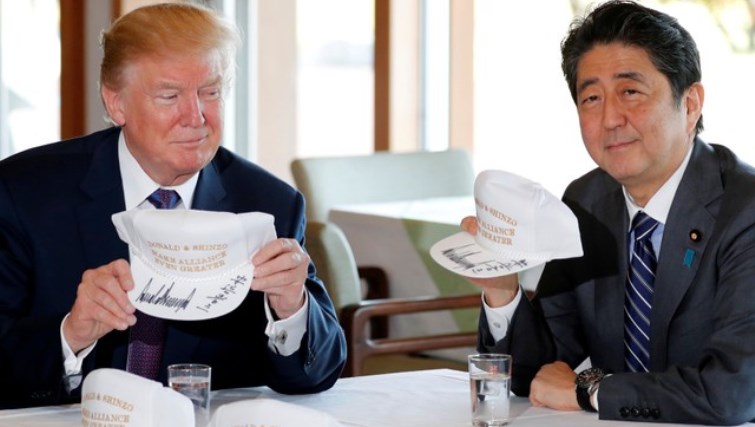 U.S. President Donald Trump and Japan's Prime Minister Shinzo Abe hold hats they signed, reading "Donald & Shinzo Make Alliance Even Greater" before lunch and a round of golf at Kasumigaseki Country Club in Kawagoe, Japan November 5, 2017. REUTERS/Jonathan Ernst     TPX IMAGES OF THE DAY