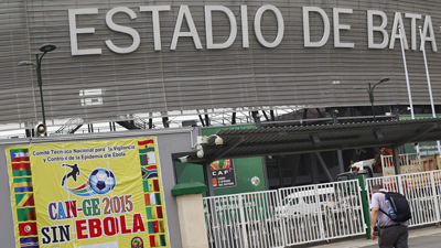 A journalist walks in front of banner about Ebola at the Estadio de Bata "Bata Stadium" which will host the opening ceremony of African Nations Cup on Saturday. Picture:SABC
