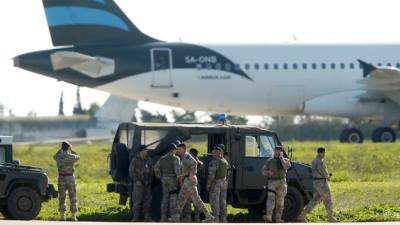 Maltese troops survey a hijacked Libyan Afriqiyah Airways Airbus A320 on the runway at Malta Airport Picture:REUTERS