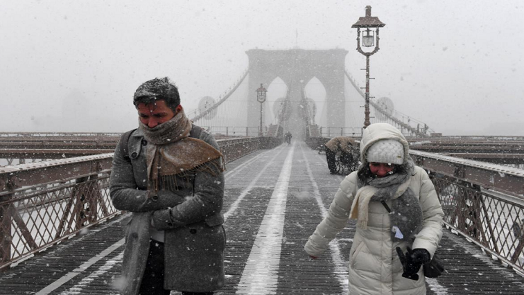 Pedestrians walk through blinding snow across the Brooklyn Bridge during storm Grayston in New York City, U.S. January 4, 2018.