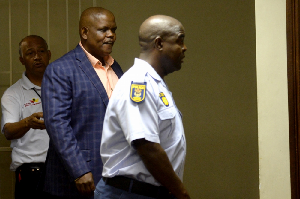 Khomotso Phahlane (c) and his two co-accused are charged with six charges of corruption.