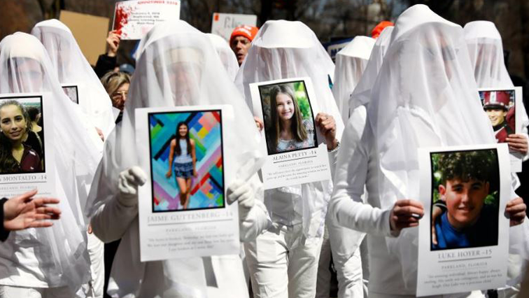 Protesters hold photos of victims of school shootings during a "March For Our Lives" demonstration demanding gun control in New York City, US.