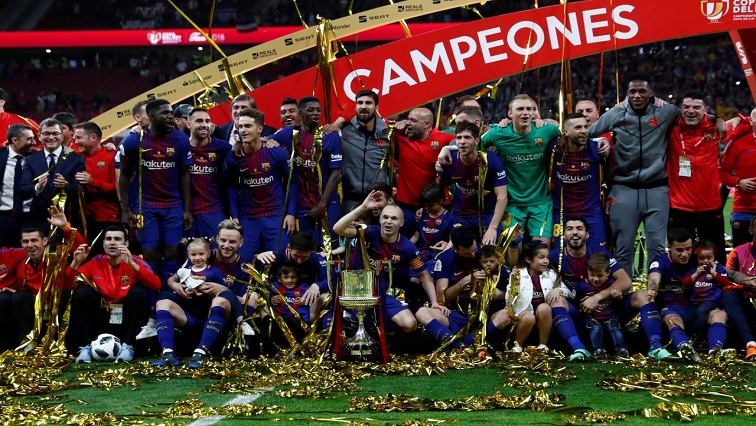 Barcelona's Andres celebrates with the trophy and team mates after the match.