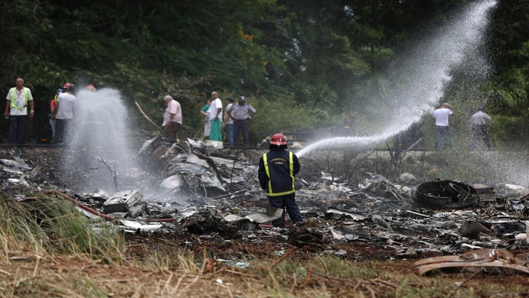 Firefighters work in the wreckage of a Boeing 737 plane that crashed in the agricultural area of Boyeros, around 20 km (12 miles) south of Havana, shortly after taking off from Havana's main airport in Cuba, May 18, 2018. REUTERS/Alexandre Meneghini