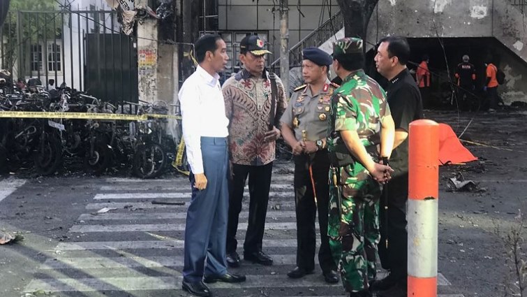 This handout photo released by Presidential Palace on May 13, 2018 shows Indonesia's President Joko Widodo (L), National Police Chief Tito Karnavian (C), Coordinating Minister for Social, Political, Legal and Security Affairs Wiranto (2nd L), and Armed Forces Chief Hadi Tjahjanto (2nd R) at the scene of an attack outside the Central Pantekosta church (Gereja Pantekosta Pusat) in Surabaya.
