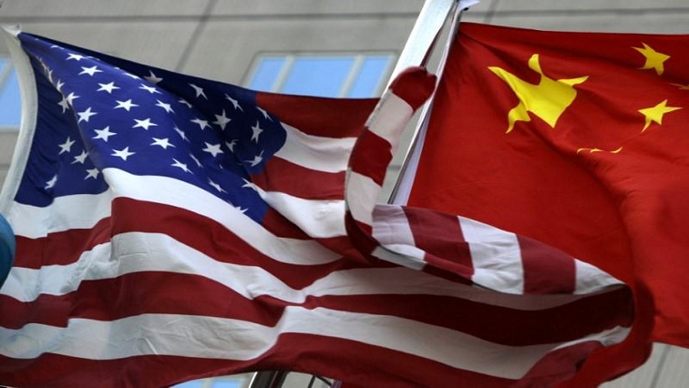 National flags of U.S. and China wave in front of an international hotel in Beijing