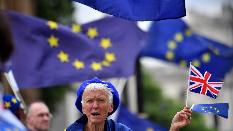 A pro-EU demonstrator waves a Union flag whilst wearing European Union flag-themed attire during an anti-Brexit protest outside the Houses of Parliament in London on June 13, 2018.