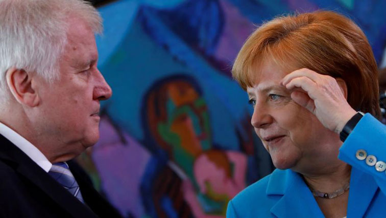 German Chancellor Angela Merkel talks to Interior Minister Horst Seehofer in Berlin.