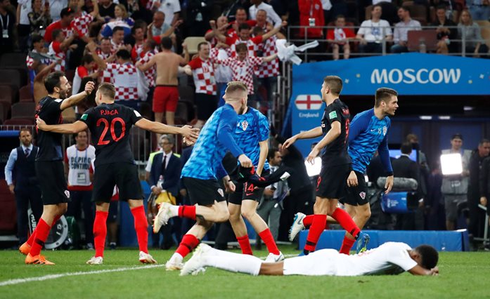 Croatia players celebrate after the match as England's Marcus Rashford looks dejected.