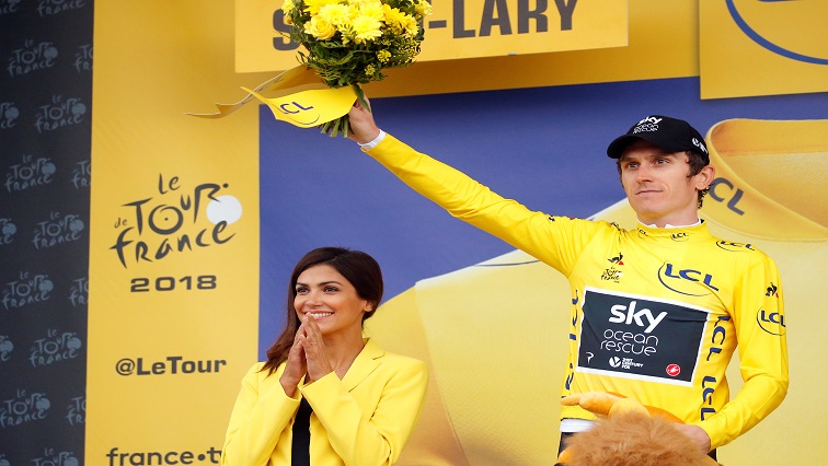 Team Sky rider Geraint Thomas of Britain celebrates on the podium, wearing the overall leader's yellow jersey.