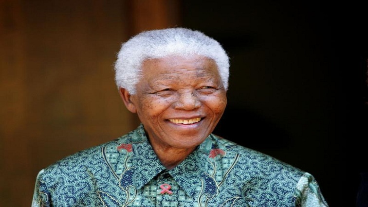 Former South African President Nelson Mandela smiles for photographers after a meeting with actor Tim Robbins at Mandela's home in Johannesburg September 22, 2005.
