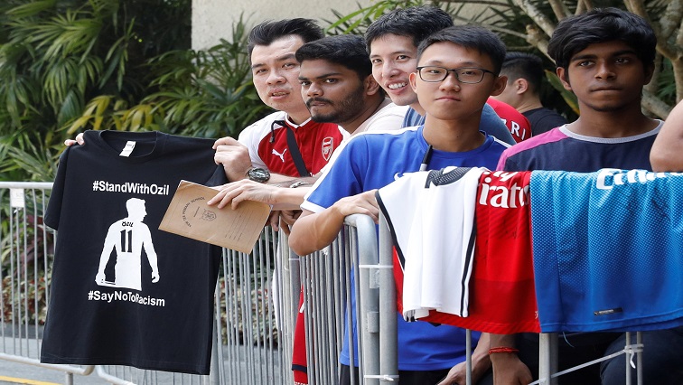 Fans wait for Arsenal and German soccer player Mesut Ozil at his hotel in Singapore July 24, 2018.