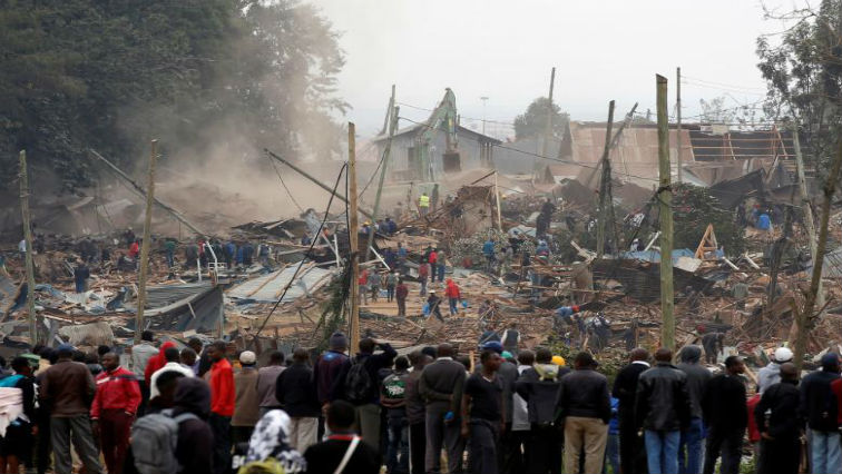 Onlookers watch as bulldozers demolish houses to make way for a new road in the Kibera slum in Nairobi, Kenya.