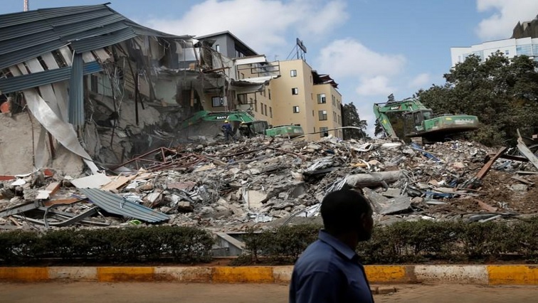 A man walks by as heavy machinery demolishes the UKAY Mall in Westlands, Nairobi, Kenya, August 14, 2018.