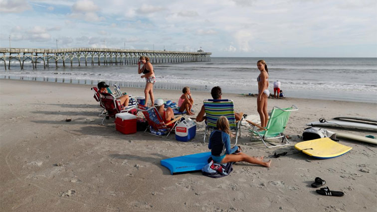 A family enjoys the surf ahead of the arrival of Hurricane Florence in Oak Island, North Carolina, U.S. September 12, 2018. REUTERS/Randall Hill