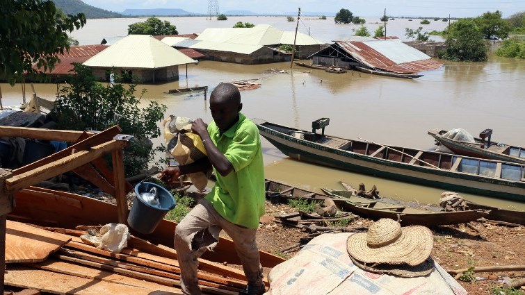 A boy carries few belongings in front of the submerged areas in the village of Otokiti.