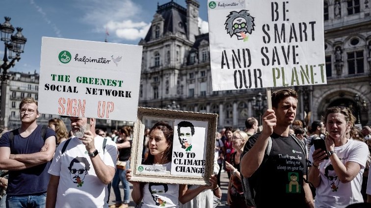 People holding placards gather at the Hotel de ville square, in Paris, to take part in the march for the climate.