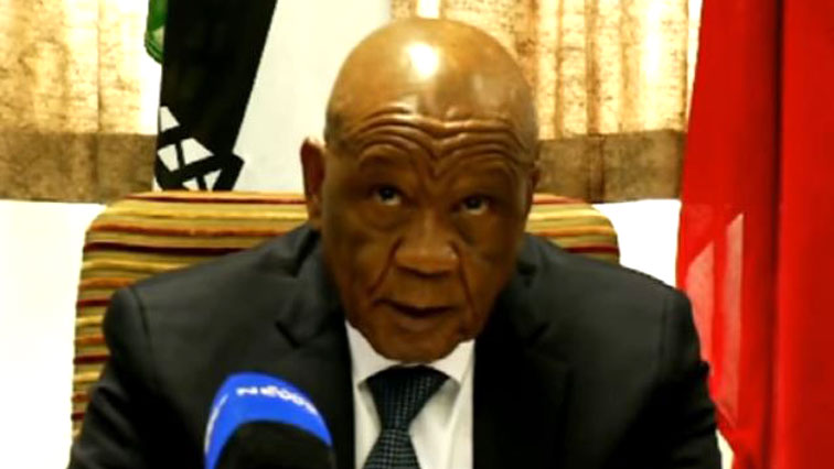 Tom Thabane sitting in front of a microphone.