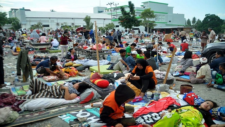 People sitting and lying on mattresses.