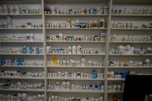 Medication stacked on shelves in a dispensary.