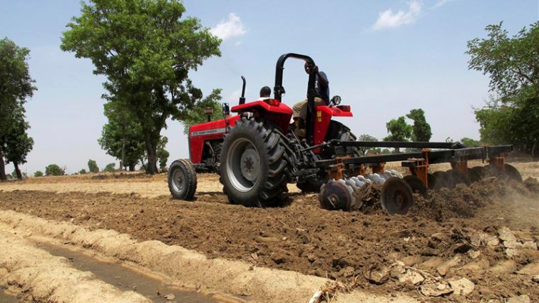 A farm tractor seen on a field