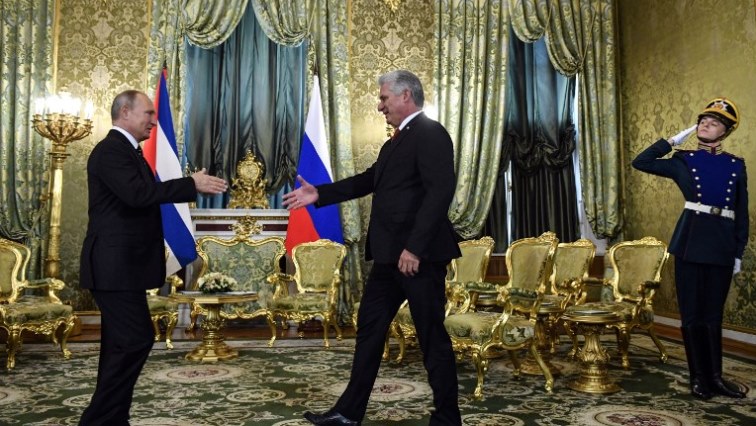 Cuban President Miguel Diaz-Canel (C) shakes hands with Russian President Vladimir Putin during their meeting at The Kremlin in Moscow