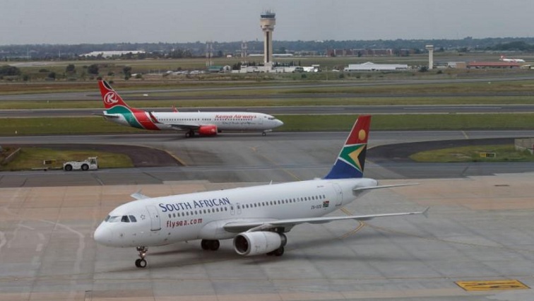 A South African Airways aircraft (bottom) arrives as a Kenya Airways aircraft prepares to take off at the OR Tambo International Airport in Johannesburg, South Africa, March 8, 2017.