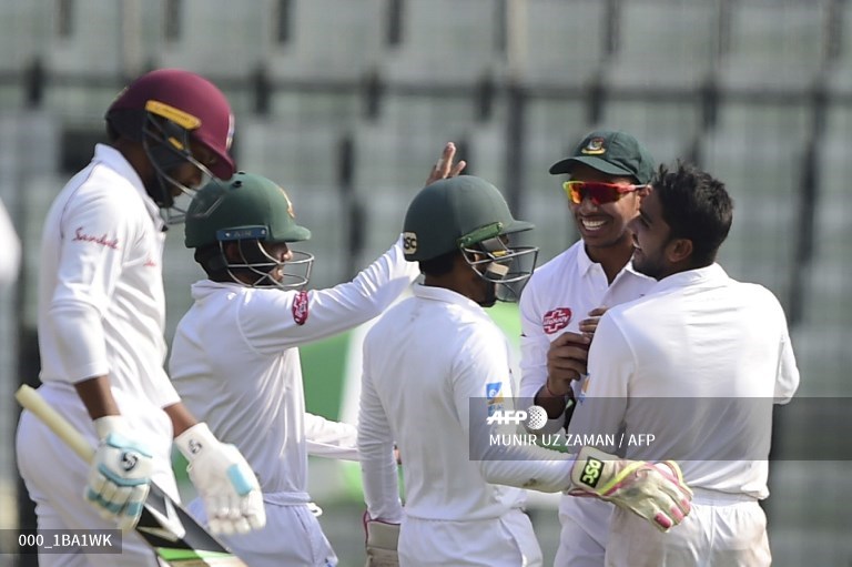 Bangladeshi cricketer Mehidy Hasan (R) celebrates with after the dismissal of West Indies cricketer Devendra Bishoo (L).