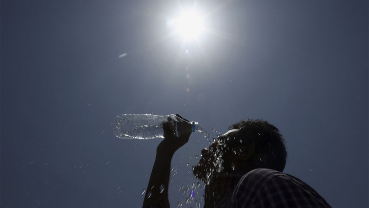 Man pouring water over his face during a heat wave.