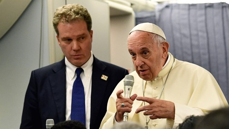 (FILES) This file picture taken on January 22, 2018, shows Pope Francis (R) answering journalists flanked by the director of the Vatican press office Greg Burke (L) during a press conference.