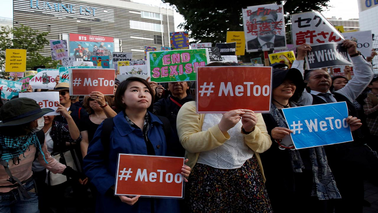 Protesters holding placards against sexual harassment