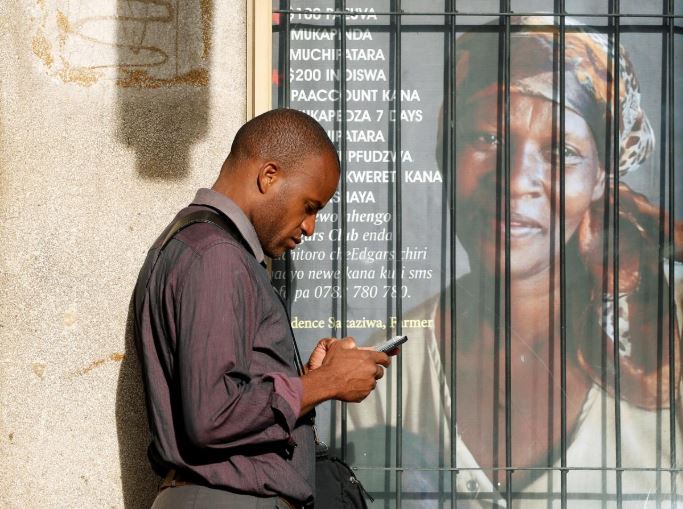 A man checks his mobile phone, in Harare, Zimbabwe.