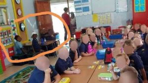 Black learners sitting at a corner table and white learners sitting on one table