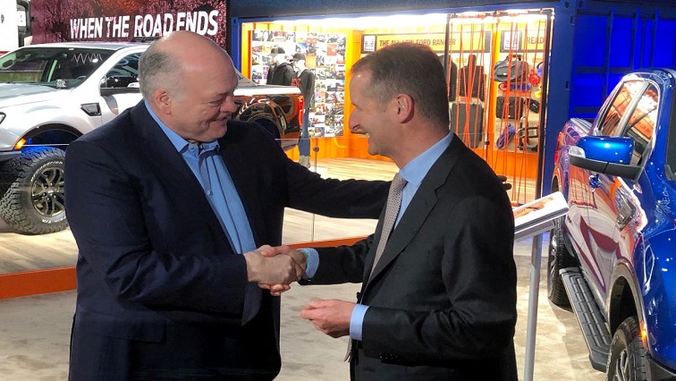 The President and CEO of Ford Motor Company Jim Hackett, shakes hands with Volkswagen CEO Herbert Diess.