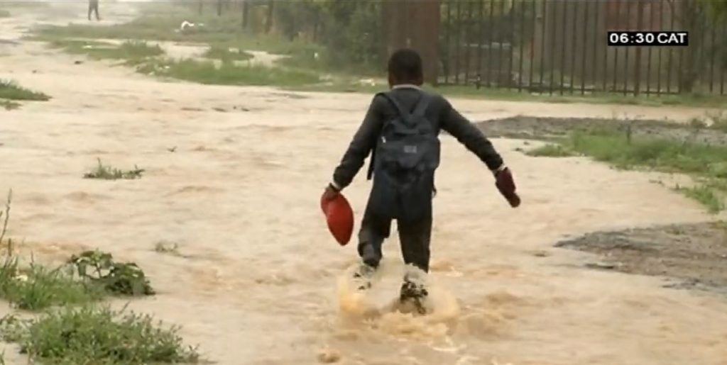 Boy walking through flooded path