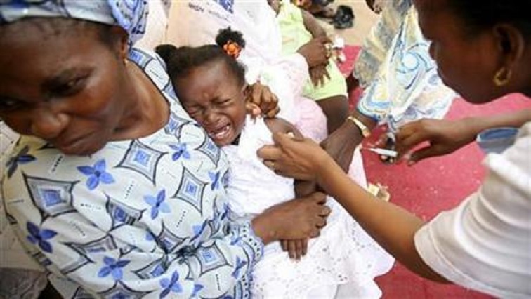 A girl cries as she receives a measles vaccine.