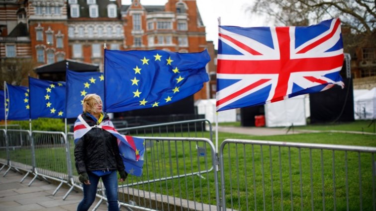 Woman walks past EU and UK flags