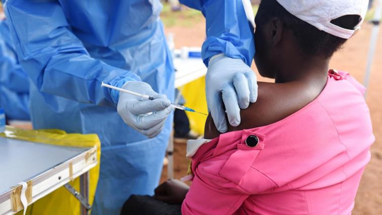 A Congolese health worker administers Ebola vaccine to a boy who had contact with an Ebola