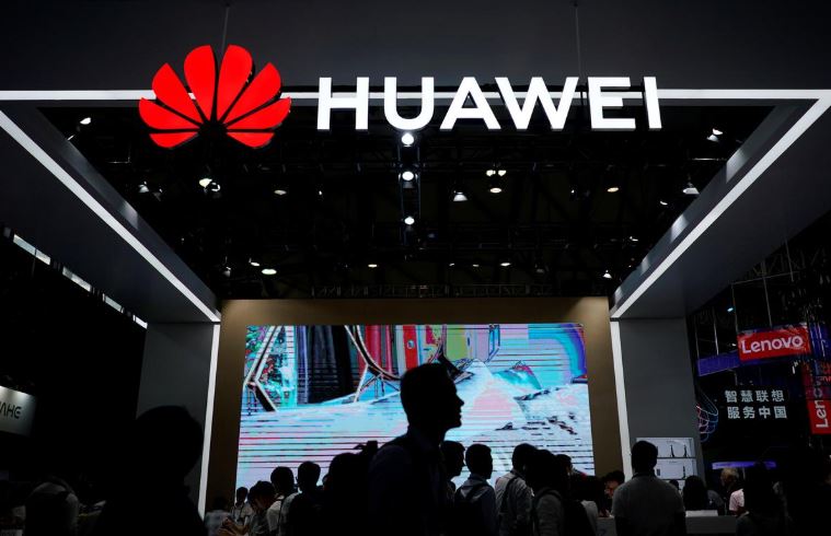 People walk past a sign board of Huawei at CES (Consumer Electronics Show) Asia 2018.