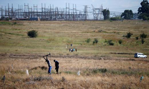 A man is seen digging to mark vacant land in Olievenhoutbosch near Centurion.