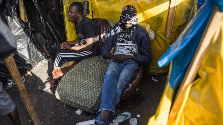 Sub-Saharan migrants lie on mattresses in a make-shift tent at the Oulad Ziane migrant camp in Casablanca.
