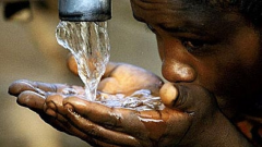 A person drinking water from a tap