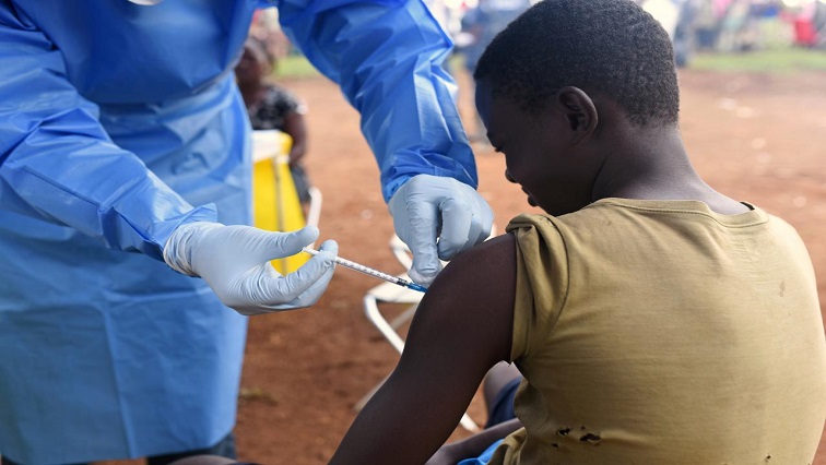 A Congolese health worker administers Ebola vaccine to a boy
