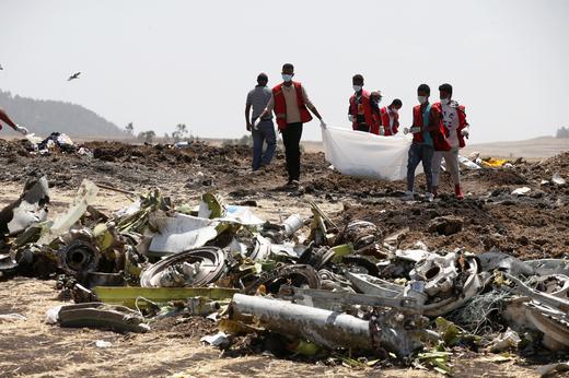 Ethiopian Red Cross workers carry a body bag with the remains of Ethiopian Airlines Flight ET 302 plane crash victims.