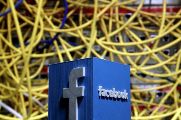 A 3D plastic representation of the Facebook logo is seen in front of displayed cables in this illustration in Zenica, Bosnia.