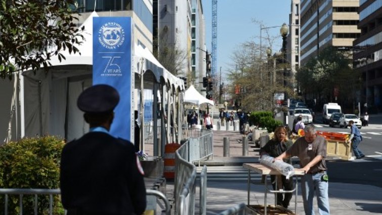 Workers are seen on a sidewalk outside of the International Monetary Fund(IMF) headquarters building in Washington, DC.