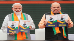Prime Minister Narendra Modi and chief of the Bharatiya Janata Party (BJP) Amit Shah, display copies of their party's election manifesto