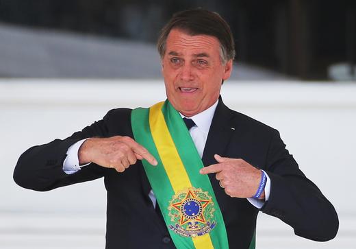 Brazil's new President Jair Bolsonaro gestures after receiving the presidential sash from outgoing President Michel Temer.