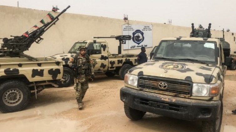 Local militiamen, belonging to a group opposed to Libyan strongman Khalifa Haftar, stand next to vehicles the group said they seized from Haftar's forces.