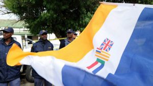 The apartheid flags displayed in public with SAPS officers in the background